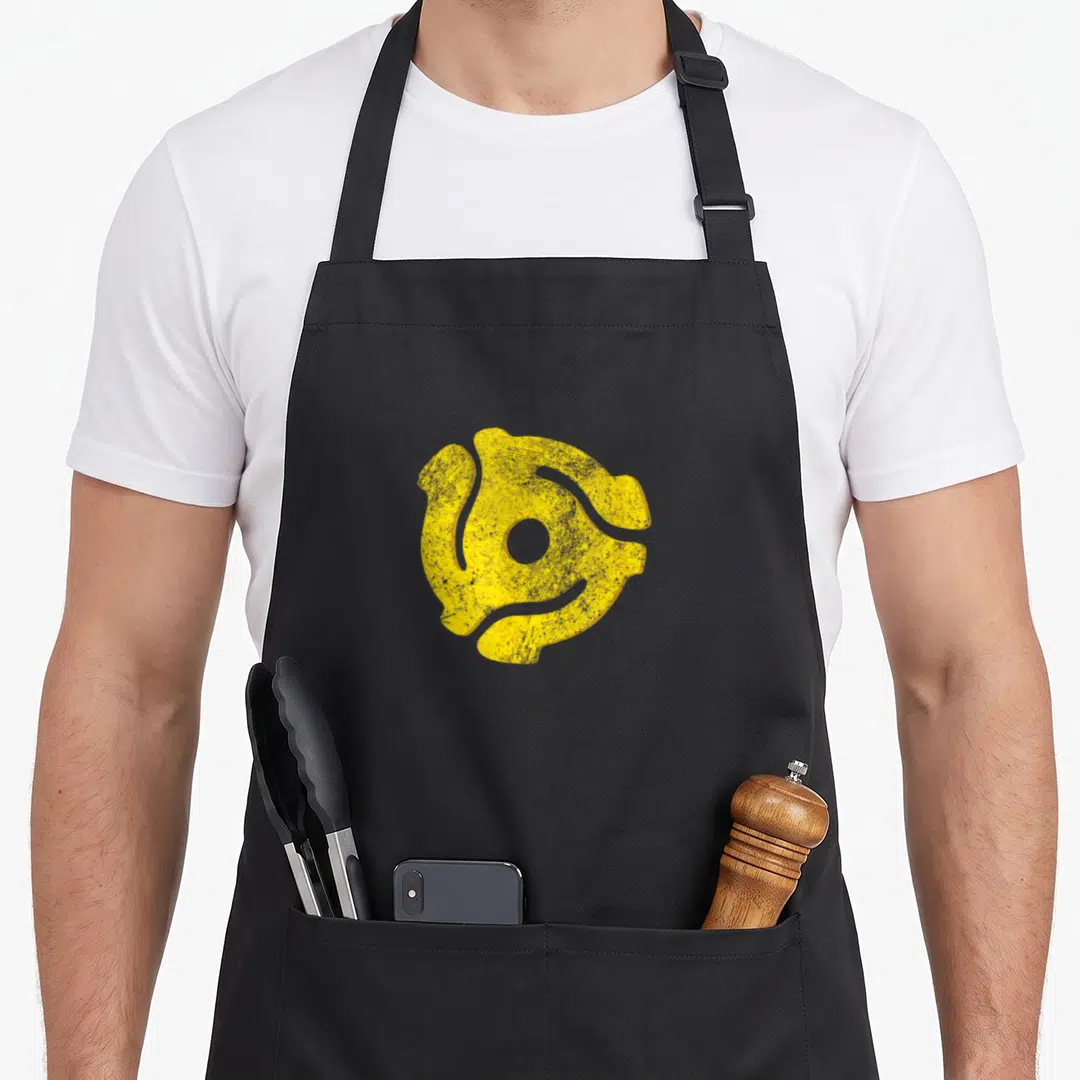 Adapter turntables and aprons - Distressed yellow 45 RPM record adapter symbol centered on grey background — shown on a black cotton canvas apron against a white background
