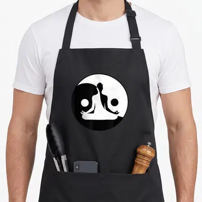 Yoga qigong apron - Minimalist black and white yin yang symbol containing a seated meditation silhouette — shown on a black cotton canvas apron against a white background