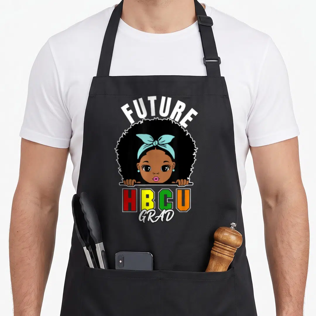 Future grade girls apron - Cartoon girl with afro and blue bow above stacked FUTURE HBCU GRAD text in red yellow green — shown on a black cotton canvas apron against a white background