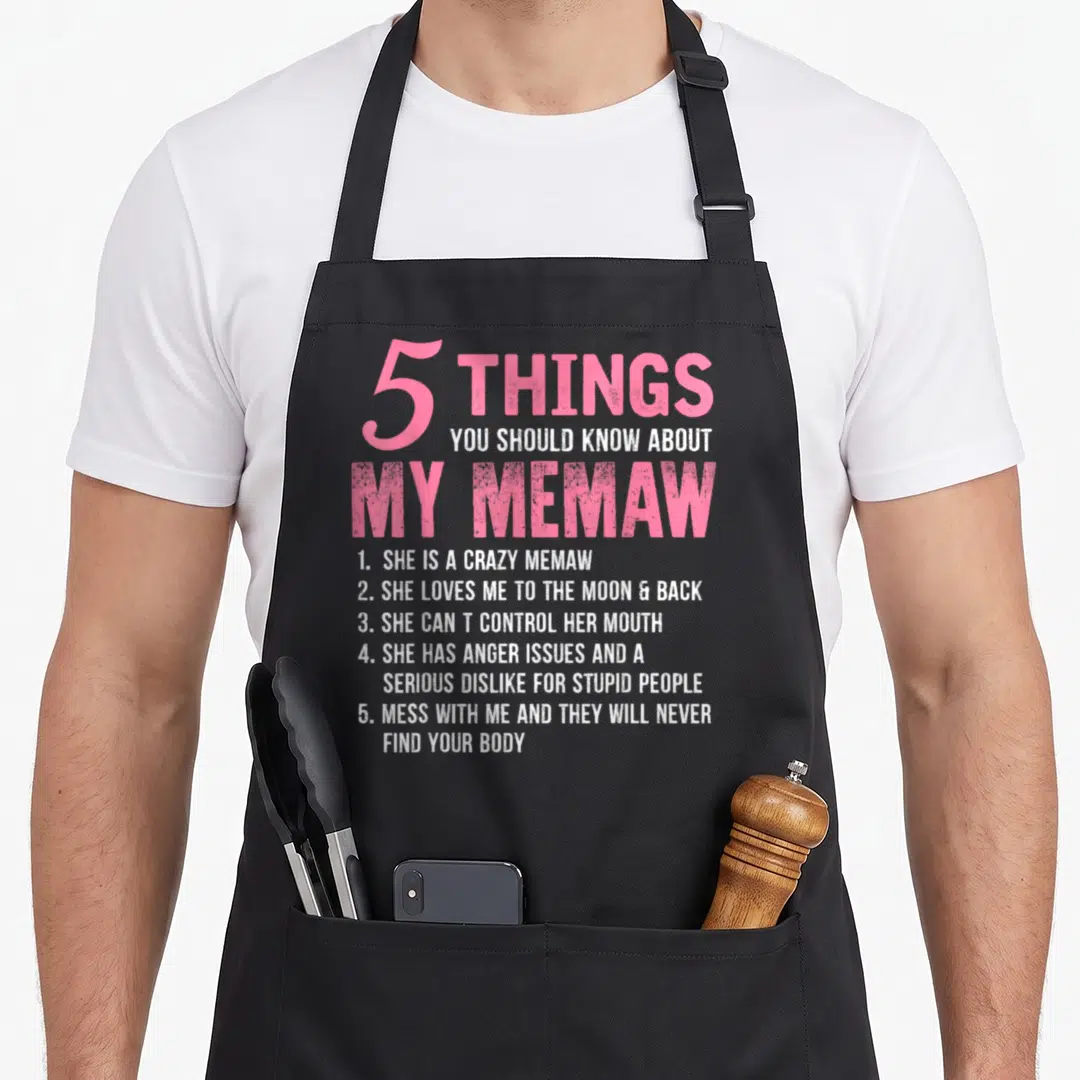 Should magpie mom apron - Pink and white typography listing 5 facts about a Memaw including anger issues and love — shown on a black cotton canvas apron against a white background