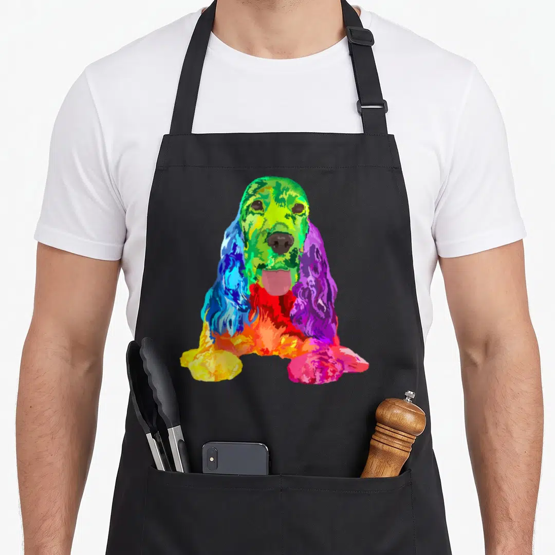 Cute dog cocker spaniel apron - Rainbow colored Cocker Spaniel dog illustration in green, blue, purple, red, and yellow — shown on a black cotton canvas apron against a white background