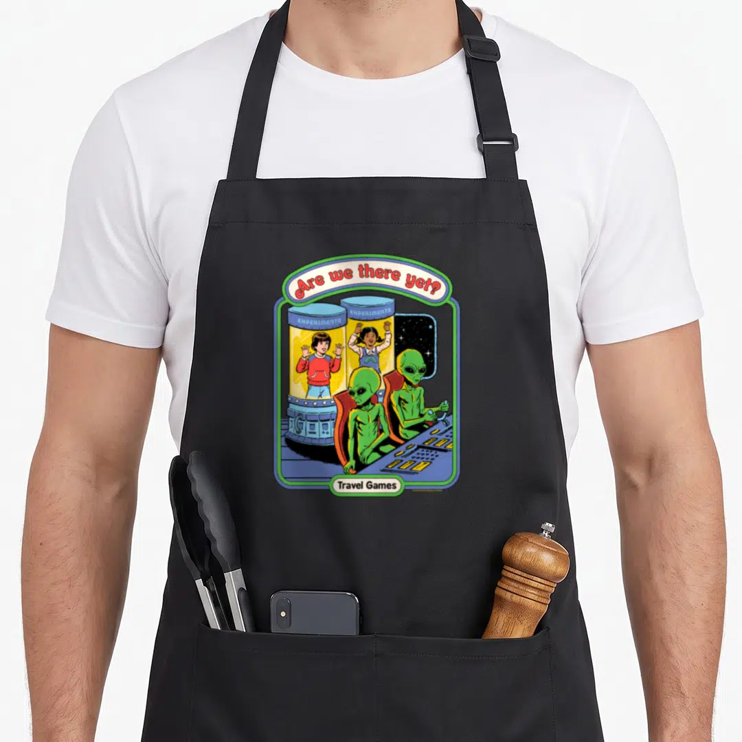 Rhode game aprons - Aliens and humans in experiment tubes under Are we there yet text — shown on a black cotton canvas apron against a white background