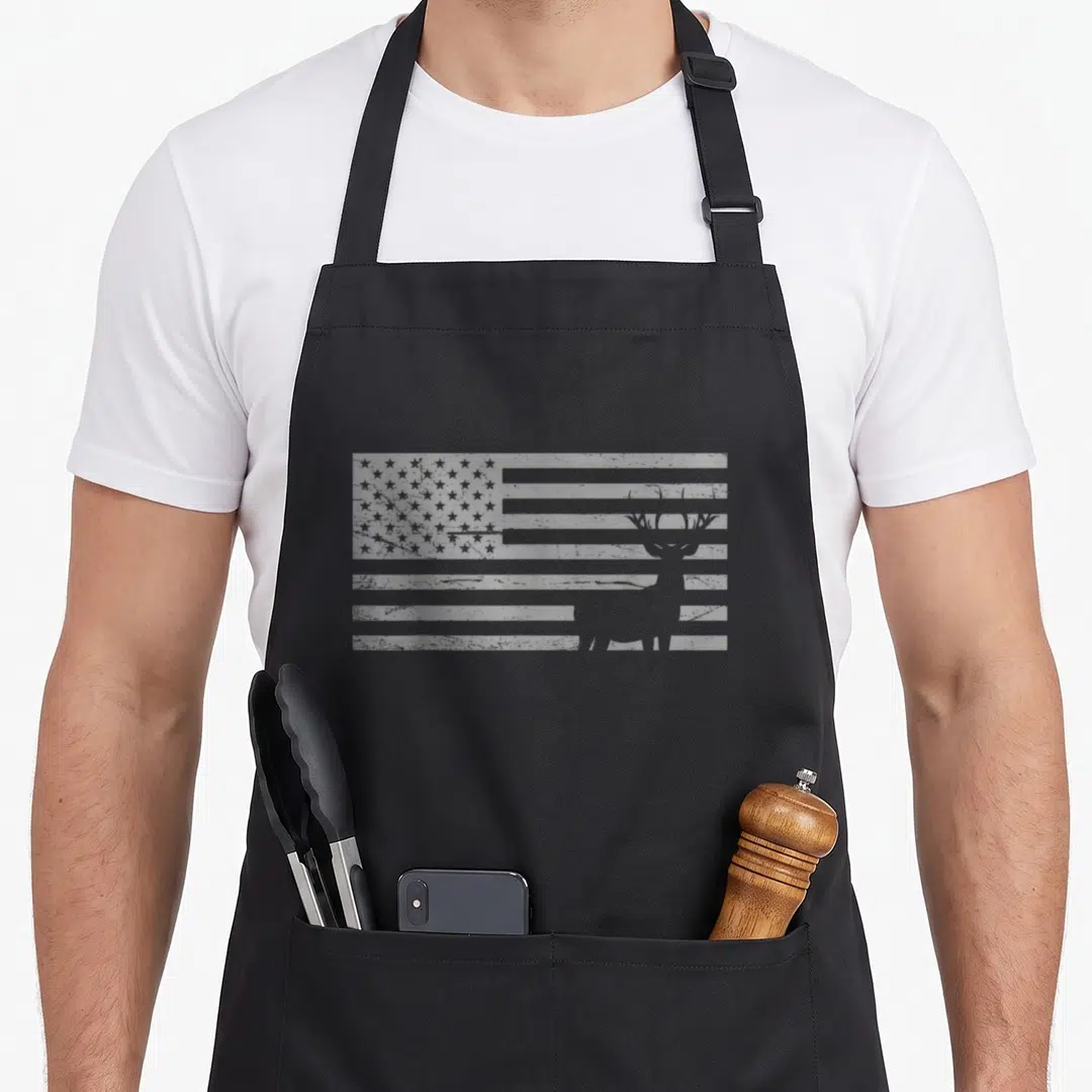 Deer hunting apron - White deer silhouette integrated into distressed USA flag graphic — shown on a black cotton canvas apron against a white background