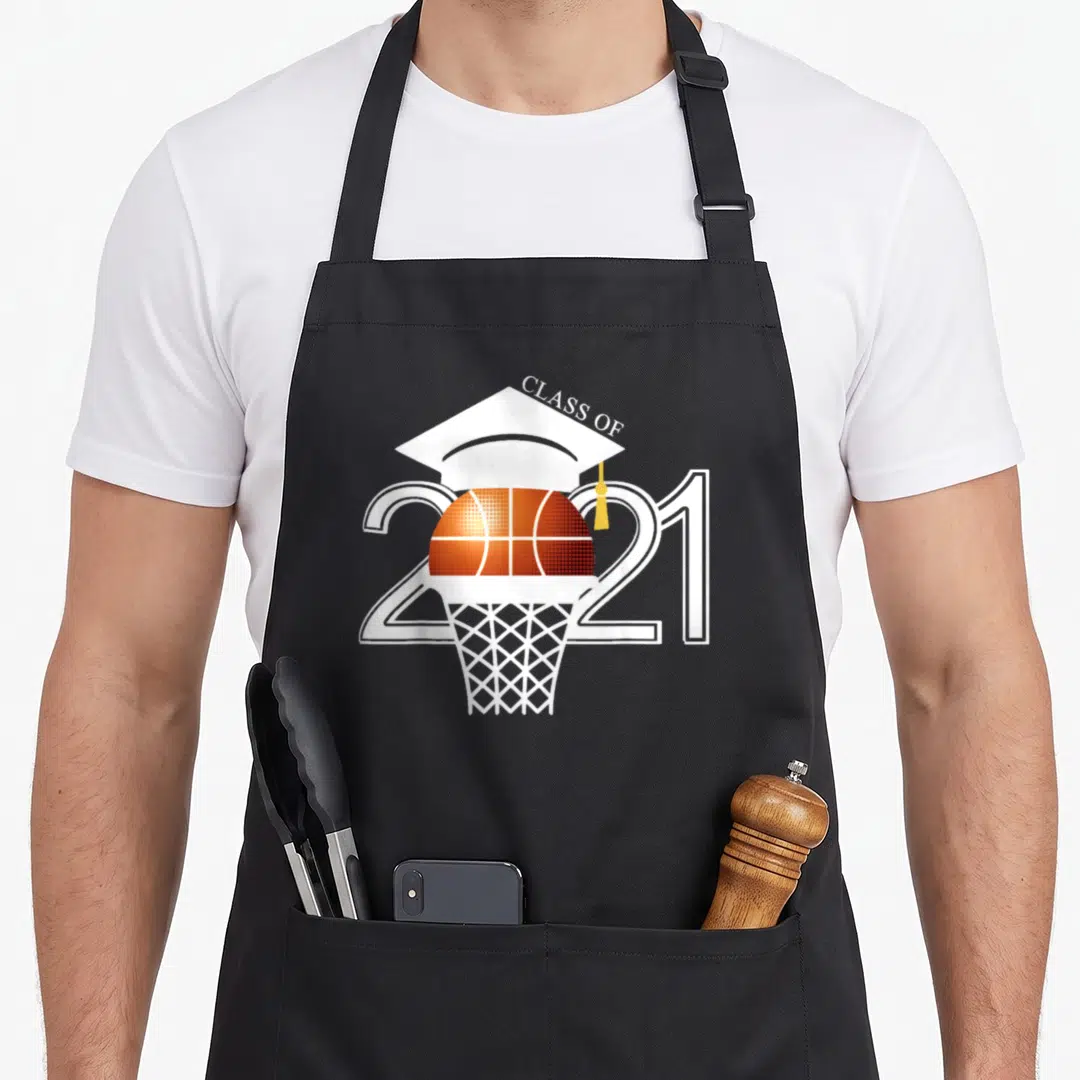 Graduation class player apron - Basketball inside hoop with graduation cap and CLASS OF 2021 text in white orange — shown on a black cotton canvas apron against a white background