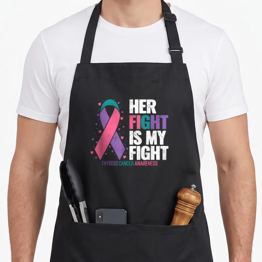 Cancer fight thyroid apron - Distressed teal pink purple ribbon surrounded by hearts next to stacked text reading — shown on a black cotton canvas apron against a white background