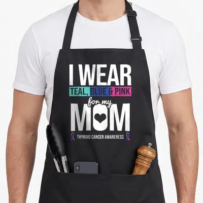 Blue thyroid apron - I WEAR TEAL BLUE PINK for my MOM thyroid cancer awareness ribbon text design — shown on a black cotton canvas apron against a white background