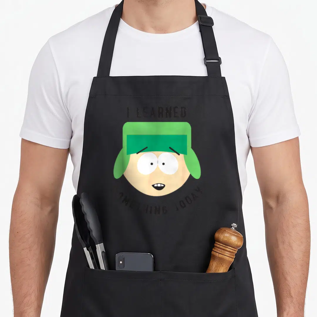 Kyle join today apron - Cartoon head with green hat and text I learned something today — shown on a black cotton canvas apron against a white background