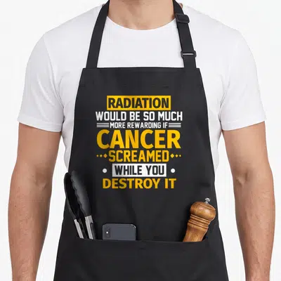 Would radiation aprons - Yellow and white stacked text reading Radiation Would Be So Much More Rewarding If Cancer — shown on a black cotton canvas apron against a white background
