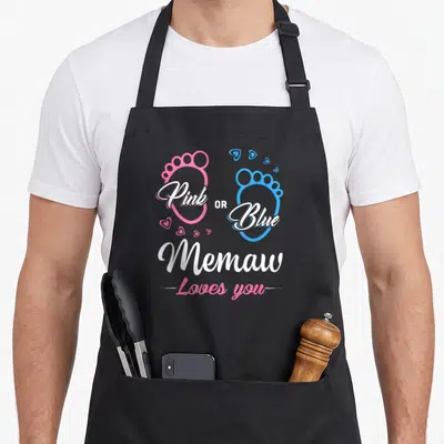 Memaw apron or apron - Pink and blue baby footprints with hearts and text Pink OR Blue Memaw Loves you — shown on a black cotton canvas apron against a white background