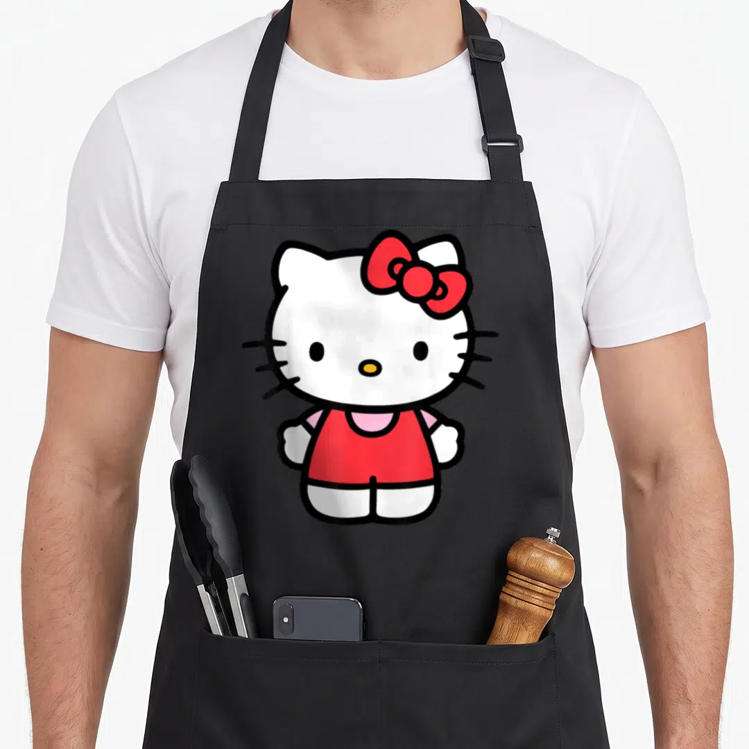 Occasion novelty apron - Centered white cartoon cat with red bow and black outlines — shown on a black cotton canvas apron against a white background