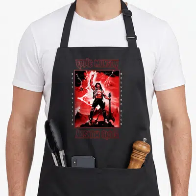 Eddie guitar apron - Red and black Eddie Munson Hellfire Club poster art with lightning and guitar — shown on a black cotton canvas apron against a white background