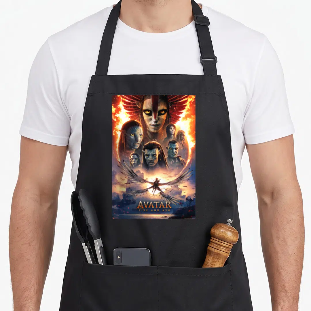 Avatar fire girl apron - Na'vi faces in fire collage with winged rider and AVATAR FIRE AND ASH text at bottom — shown on a black cotton canvas apron against a white background