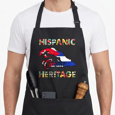 Cuba hispanic aprons - HISPANIC Cuban HERITAGE text surrounding a map of Cuba filled with flag colors and patterns — shown on a black cotton canvas apron against a white background