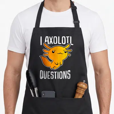 Retro axolotl questions apron - Orange cartoon axolotl flanked by I AXOLOTL above and QUESTIONS below in white block — shown on a black cotton canvas apron against a white background