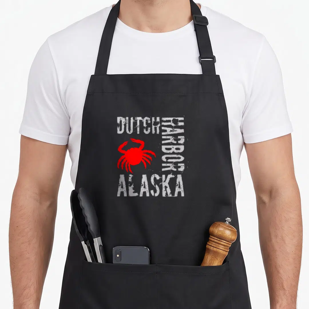 Alaska dutch apron - Red crab graphic with distressed white text DUTCH HARBOR ALASKA on black background — shown on a black cotton canvas apron against a white background