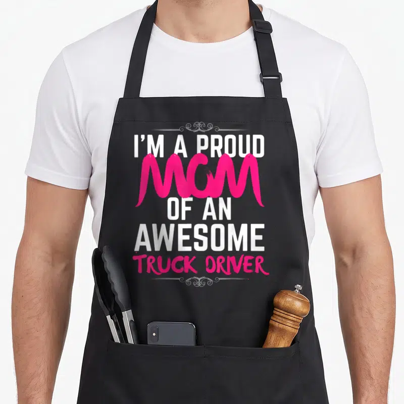 Driver proud truck apron - Pink and white stacked text reading I'M A PROUD MOM OF AN AWESOME TRUCK DRIVER — shown on a black cotton canvas apron against a white background