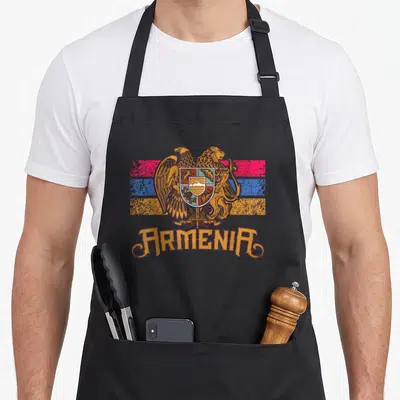 Family country apron - Armenia coat of arms over orange purple red blue stripes with curved text below — shown on a black cotton canvas apron against a white background