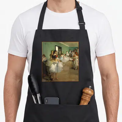 Edgar art class apron - Ballerinas in white tutus in a teal studio with an instructor standing by a mirror — shown on a black cotton canvas apron against a white background
