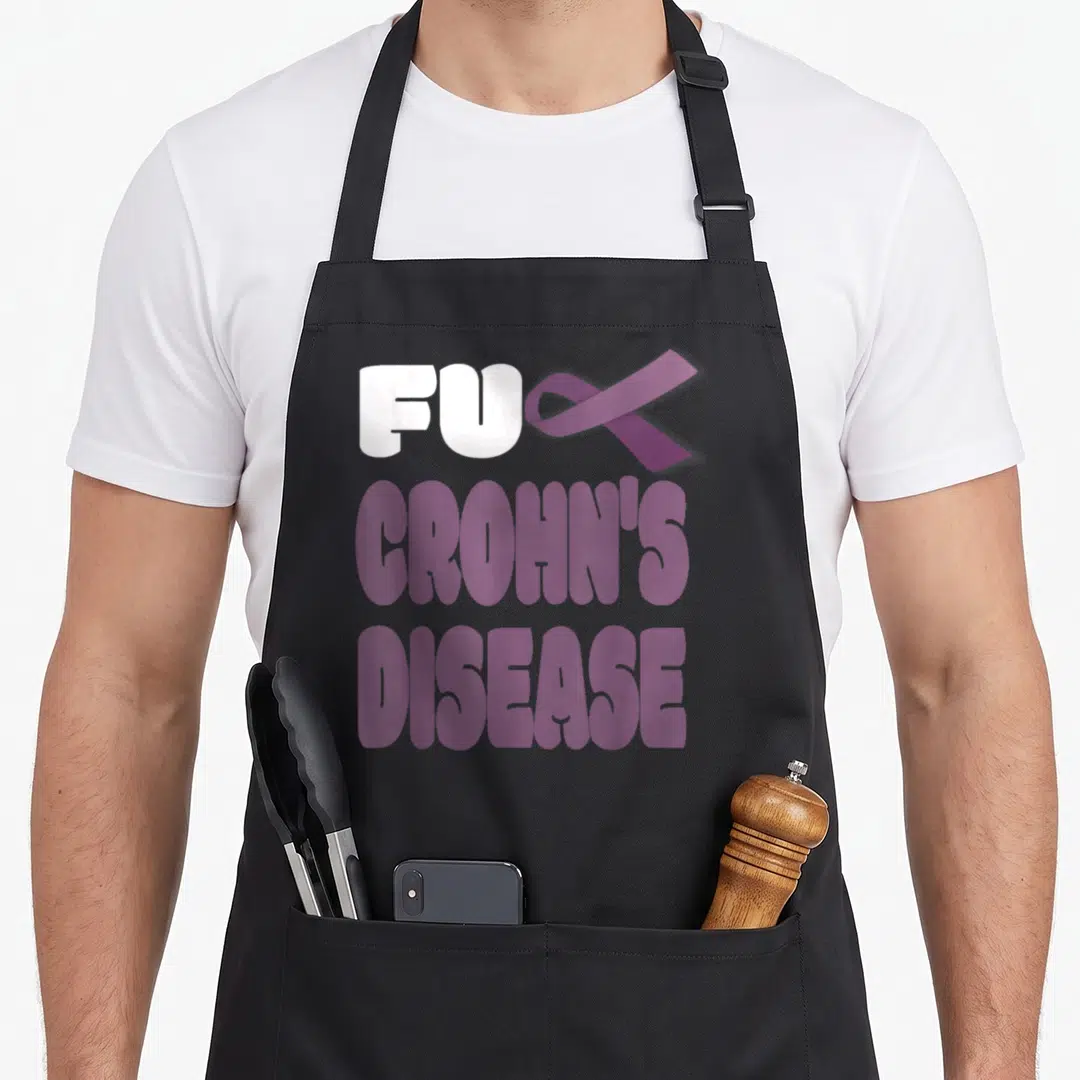 Crohn disease awareness ribbon apron - Stacked text FU CROHN'S DISEASE with purple ribbon replacing CK letter — shown on a black cotton canvas apron against a white background
