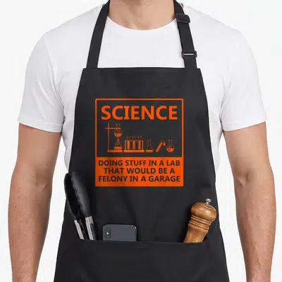 Nerd chemistry apron - Orange border with SCIENCE text, lab flasks, and felony punchline text — shown on a black cotton canvas apron against a white background