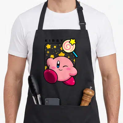 Lollipop birthday age apron - Pink Kirby winking on grey star panel with star lollipop and KIRBY text — shown on a black cotton canvas apron against a white background