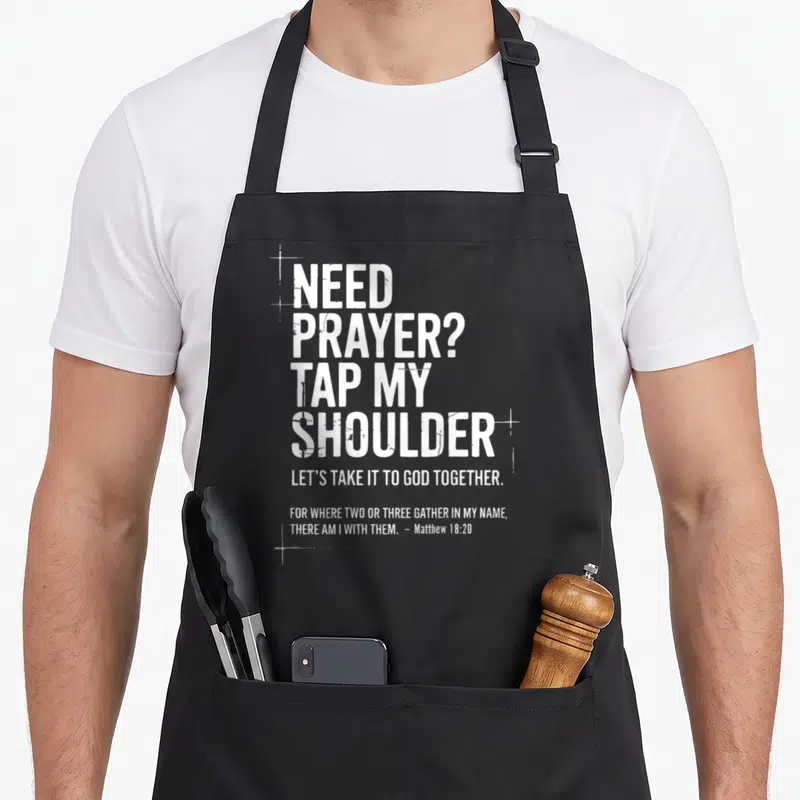 Prayer bible verse apron - Distressed white text reading NEED PRAYER TAP MY SHOULDER with small cross outlines — shown on a black cotton canvas apron against a white background