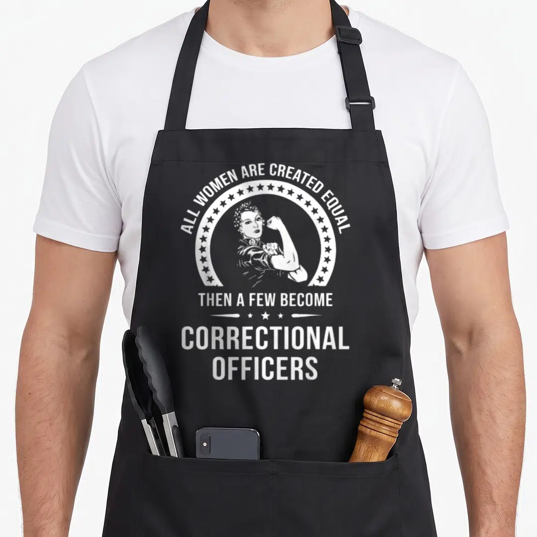 Correctional embroidery apron - White text all women created equal then become correctional officers around flexing — shown on a black cotton canvas apron against a white background