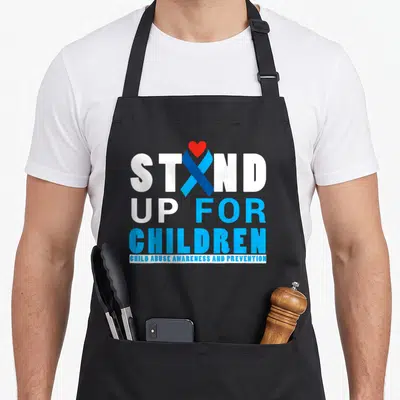 Awareness child abuse prevention apron - White and blue text reading Stand Up For Children with a blue ribbon and red — shown on a black cotton canvas apron against a white background