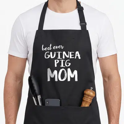 Cute guinea pigs apron - Stacked white text reading best ever GUINEA PIG MOM in brush font — shown on a black cotton canvas apron against a white background