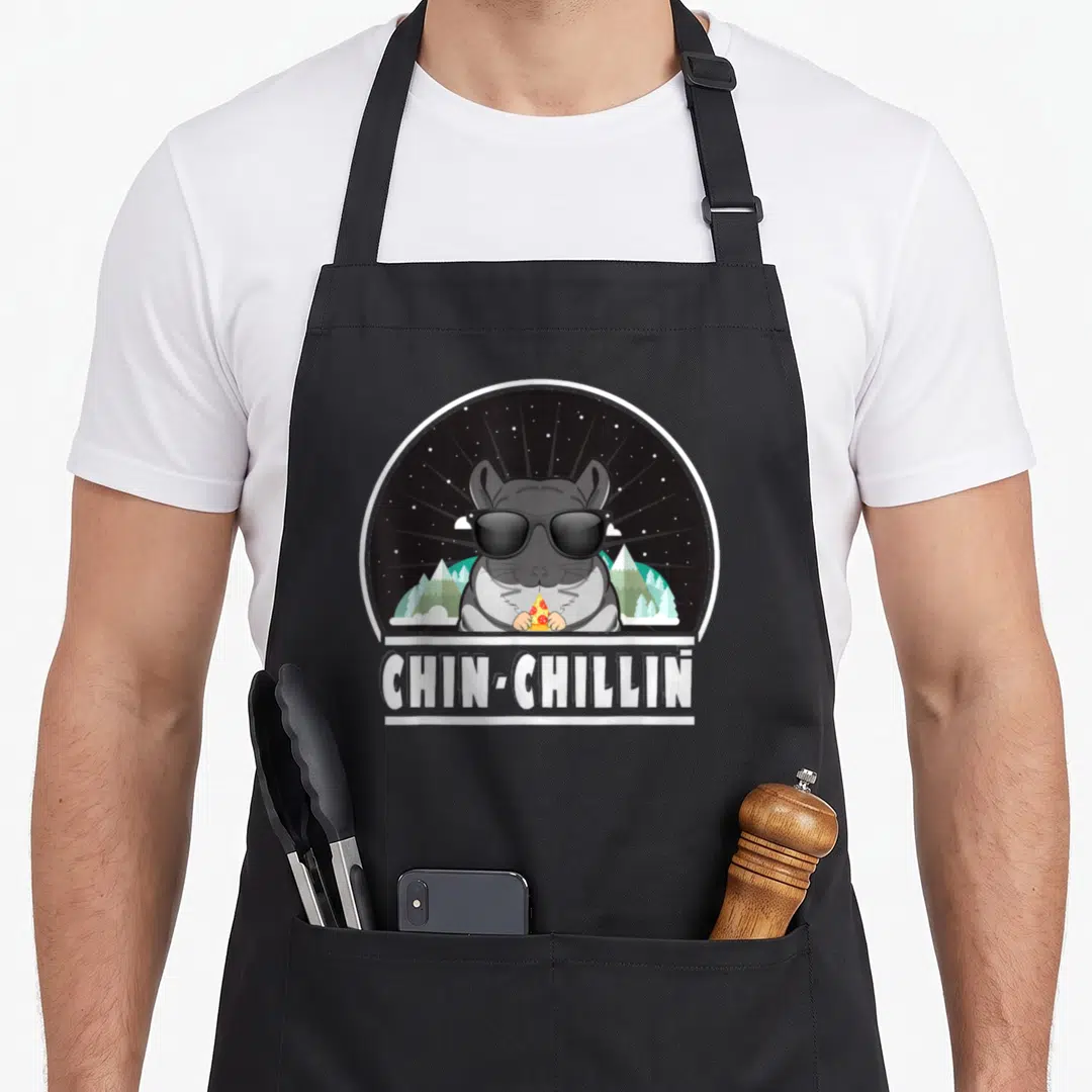 Chin crazy chinchilla man apron - Cartoon chinchilla in sunglasses holding pizza under a starry sky with text — shown on a black cotton canvas apron against a white background