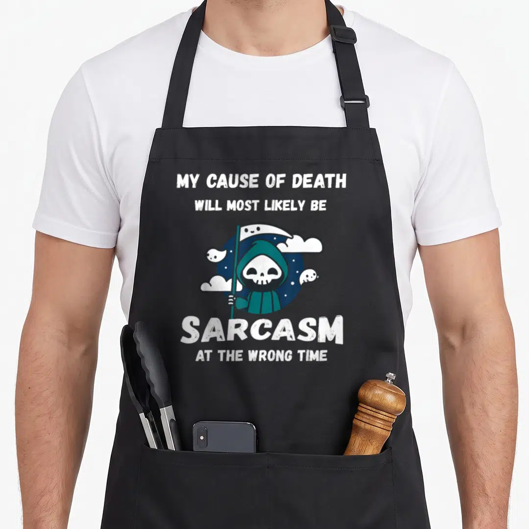 Sarcasm joke apron - Cartoon grim reaper in teal holding scythe with white text about sarcasm cause of death — shown on a black cotton canvas apron against a white background