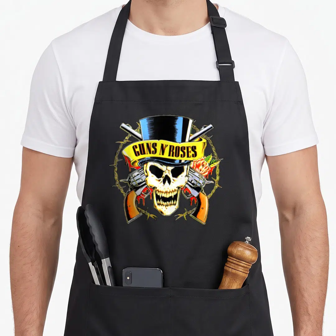 Rose hat gun apron - Skull in blue top hat with crossed guns, yellow ribbon text, barbed wire circle, and rose on right — shown on a black cotton canvas apron against a white background