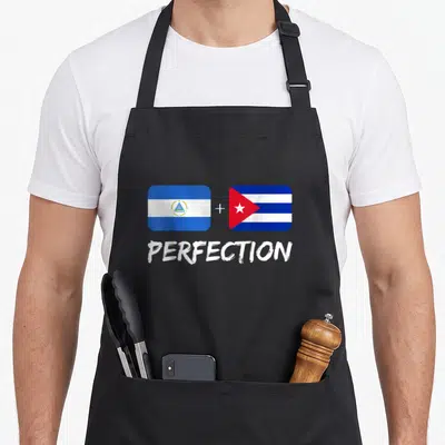 Cuban perfection heritage aprons - Two rectangular flags with plus sign and word PERFECTION in white — shown on a black cotton canvas apron against a white background