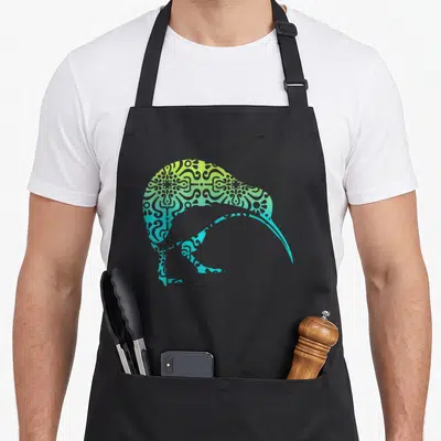 Tribal new zealand apron - Kiwi bird silhouette filled with blue green yellow gradient mandala pattern — shown on a black cotton canvas apron against a white background