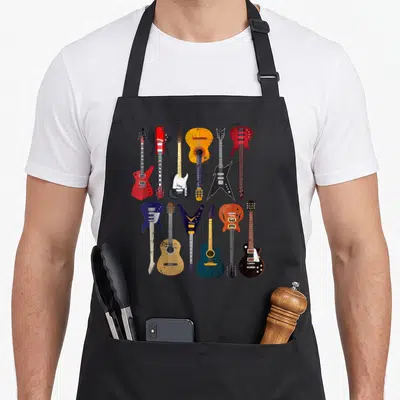 Collection guitar apron - Twelve retro guitars in red, yellow, blue, black, and orange standing in two rows of six — shown on a black cotton canvas apron against a white background