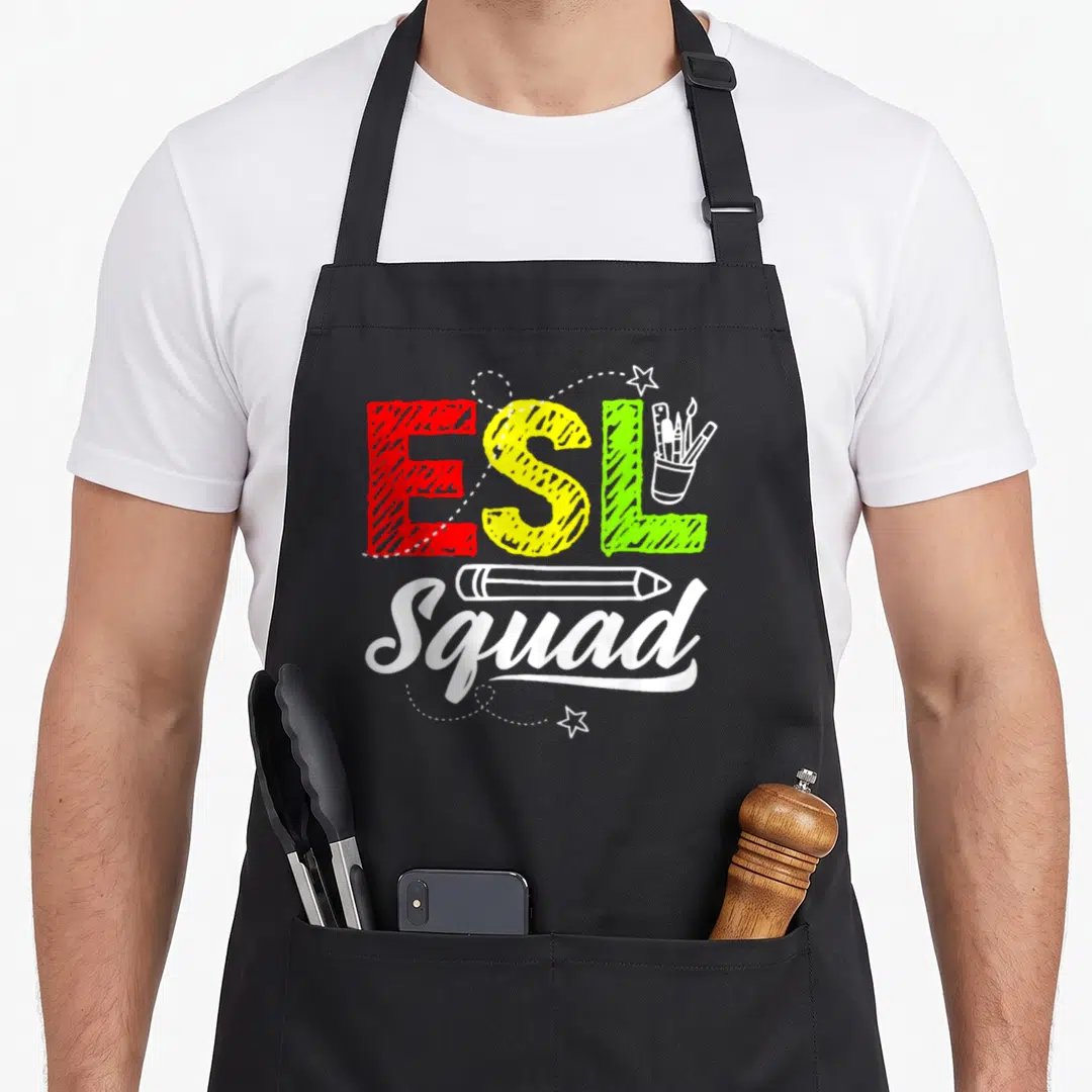 Esl linguist teacher apron - ESL Squad text with pencil and cup of supplies in red yellow green white — shown on a black cotton canvas apron against a white background