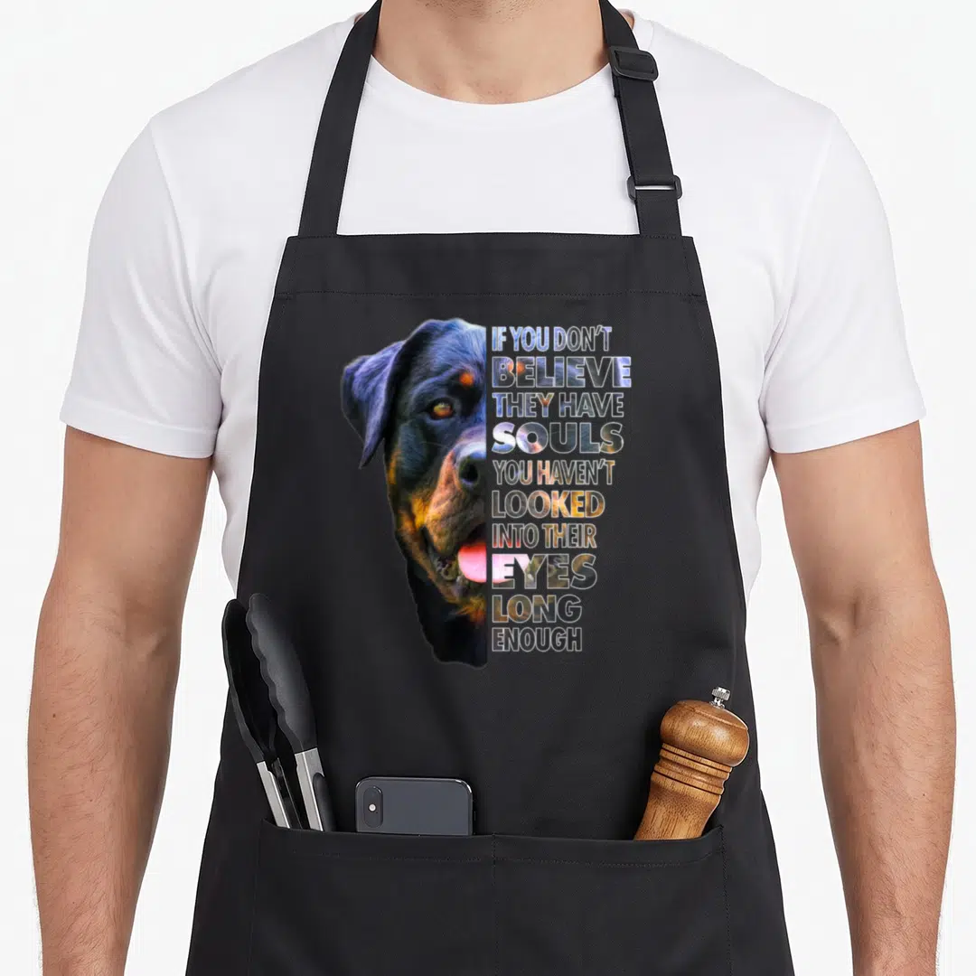 Rotty dog apron - Dog head photo beside stacked text containing the same image in black brown and white — shown on a black cotton canvas apron against a white background