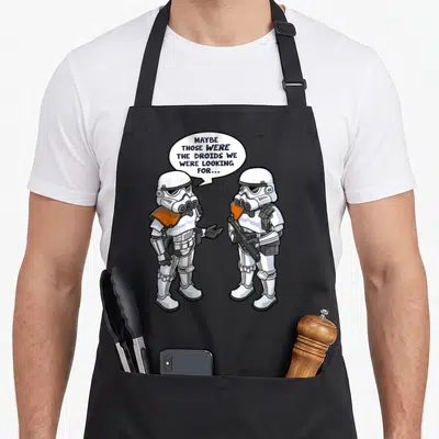 Wrong star war apron - Two cartoon stormtroopers with white orange accents and speech bubble reading MAYBE THOSE WERE — shown on a black cotton canvas apron against a white background