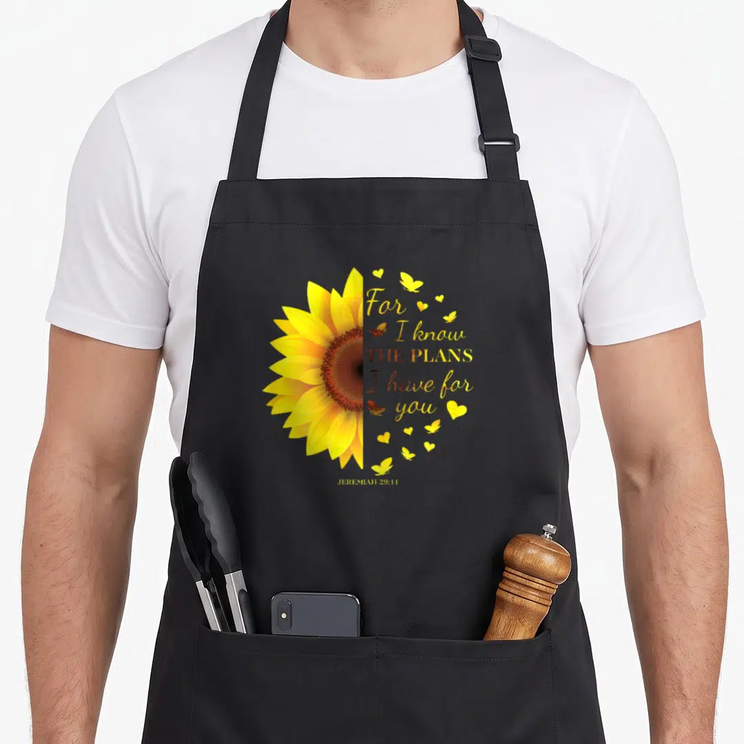 Jeremiah christian by alexis mae apron - Yellow sunflower half and Jeremiah 29:11 verse with butterflies and hearts — shown on a black cotton canvas apron against a white background
