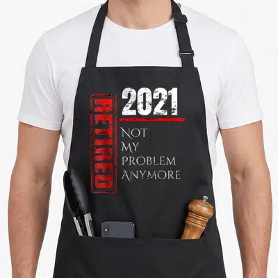Retro anymore retirement apron - Red stamped RETIRED next to 2021 and not my problem anymore in white distressed text — shown on a black cotton canvas apron against a white background