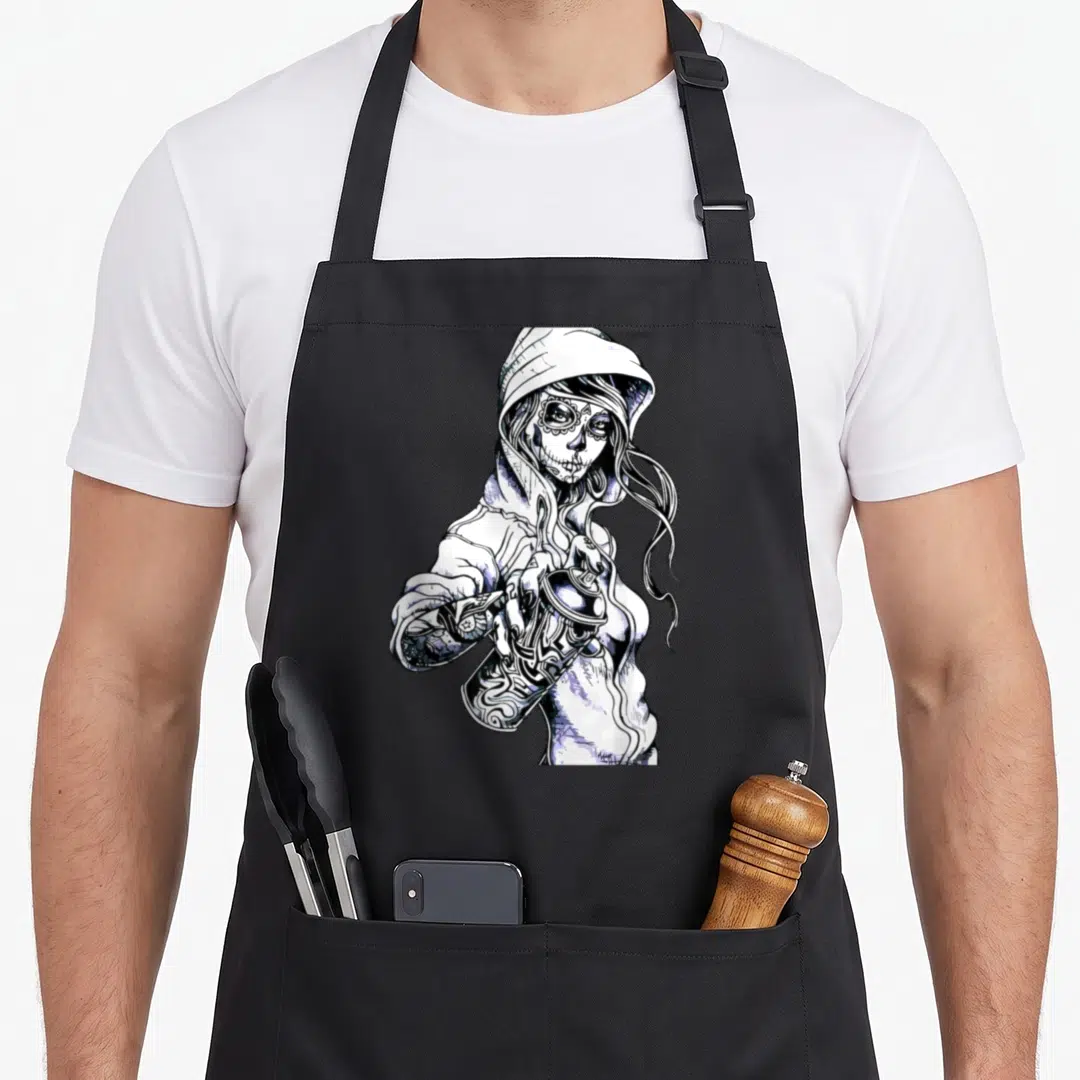 Skeleton tag apron - Black and white line art of a hooded woman with sugar skull makeup holding a spray paint can — shown on a black cotton canvas apron against a white background