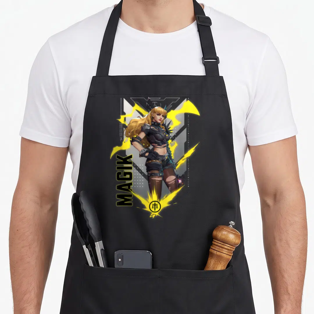 Gamerverse super hero aprons - Vertical MAGIK text next to female character with yellow energy sparks and bottom logo — shown on a black cotton canvas apron against a white background