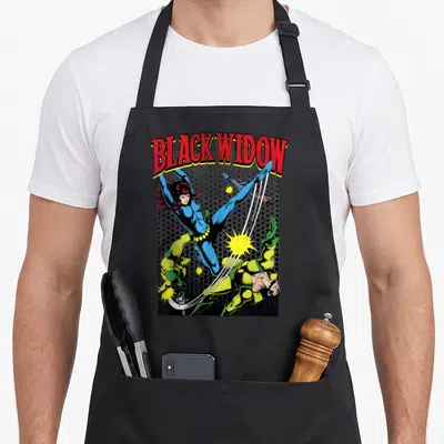 Comic swing apron - Black Widow kicking opponent in blue suit against halftone dots with red arched text — shown on a black cotton canvas apron against a white background