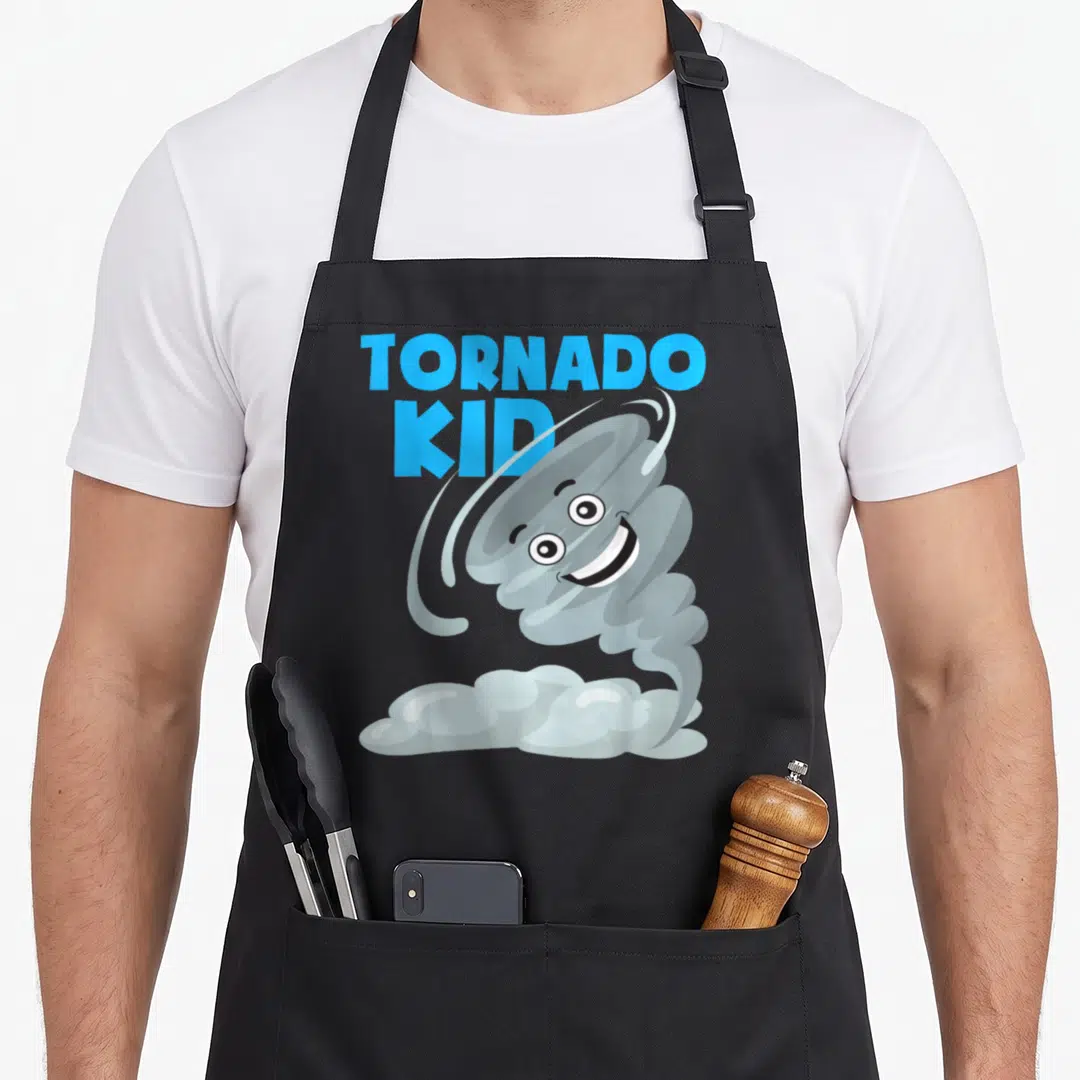 Hurricane hunter apron - TORNADO KID text next to a smiling grey cartoon tornado on a cloud base in blue and white art — shown on a black cotton canvas apron against a white background