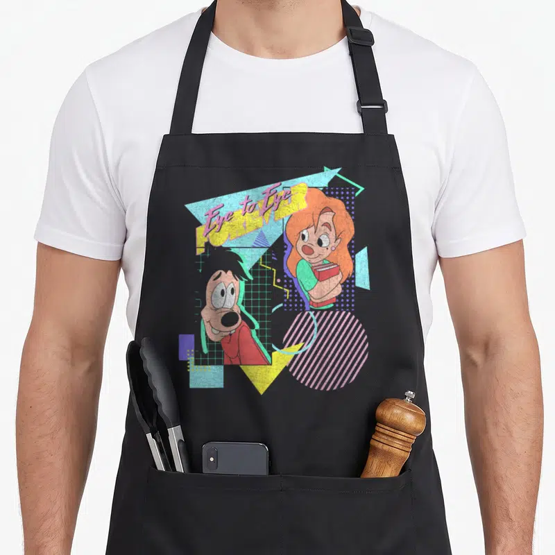 Max movie poster apron - Retro characters Eye to Eye FOREVER text pink yellow blue orange geometric shapes dot pattern — shown on a black cotton canvas apron against a white background