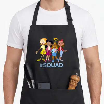 Channel family aprons - Four cartoon girls in yellow purple blue and red standing above #SQUAD text — shown on a black cotton canvas apron against a white background