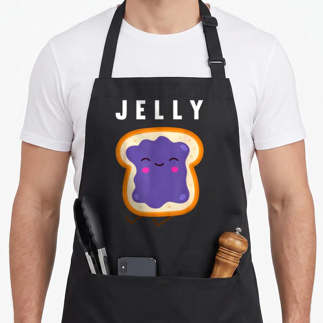 Friend butter apron - Cartoon toast with purple jelly face and white JELLY text — shown on a black cotton canvas apron against a white background