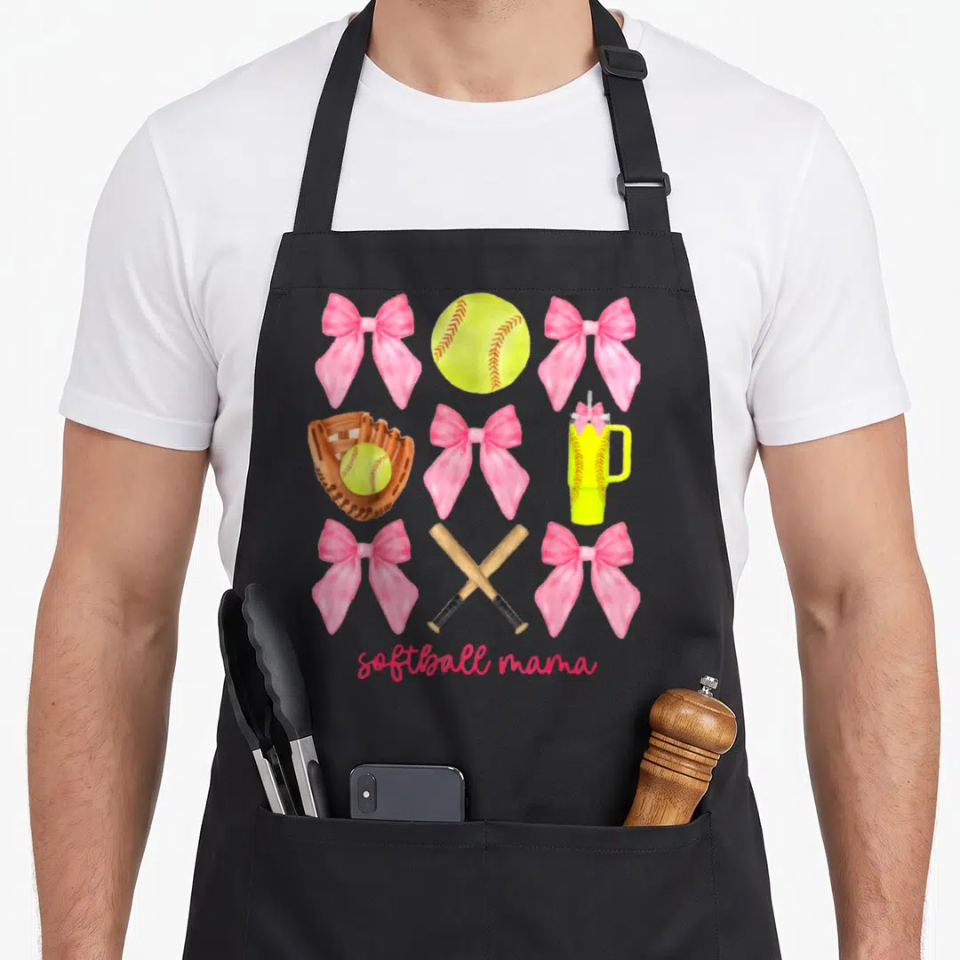 Softball bow apron - Pink bows, yellow softball, brown mitt, crossed bats, and tumbler in a grid layout — shown on a black cotton canvas apron against a white background