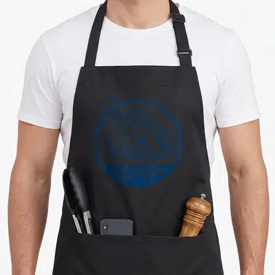 Tow car apron - Blue line art tow truck in circle with TOW MATER TOWING & SALVAGE text — shown on a black cotton canvas apron against a white background