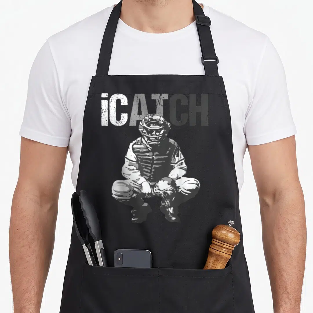 Icatch baseball apron - Distressed iCATCH text above a crouching catcher in grey and white graphics — shown on a black cotton canvas apron against a white background